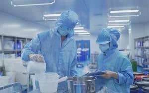 ELOV production team weighing cosmetic raw materials before processing
